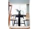 A bright dining area showcasing a dark round table and stylish chairs under a large window at 9369 Longs Peak Dr, Commerce City, CO 80640
