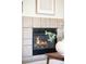 Close-up of a modern fireplace with neutral tile surround, offering warmth and a focal point in the living space at 9369 Longs Peak Dr, Commerce City, CO 80640