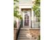 Charming home entrance features a brick staircase, black iron railing, and a green front door with sidelight at 9369 Longs Peak Dr, Commerce City, CO 80640