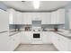 Well-lit kitchen with white cabinets, modern appliances, and a gray countertop on blue accent walls at 9369 Longs Peak Dr, Commerce City, CO 80640