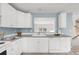 Bright kitchen showcasing white cabinets, gray countertops, and stainless steel appliances at 9369 Longs Peak Dr, Commerce City, CO 80640