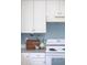 Bright kitchen featuring white cabinets, gray countertops, and modern appliances with blue accent walls at 9369 Longs Peak Dr, Commerce City, CO 80640