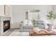 Comfortable living room with fireplace, gray sofa, and natural decor offering a relaxing and stylish space at 9369 Longs Peak Dr, Commerce City, CO 80640