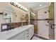 Elegant bathroom features a glass shower, double vanity, round mirrors, and modern lighting at 8155 W Tennessee Dr, Lakewood, CO 80226