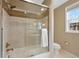 Bathroom featuring a glass-enclosed tub/shower combination with a window and modern fixtures at 8155 W Tennessee Dr, Lakewood, CO 80226