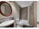 Updated bathroom featuring a tiled shower with a tub, framed mirror, and sleek fixtures at 8155 W Tennessee Dr, Lakewood, CO 80226