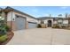 Home featuring a three-car garage, stone accents, and a spacious driveway at 8155 W Tennessee Dr, Lakewood, CO 80226