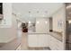 Open-concept kitchen with white cabinets, gray countertops, stainless steel appliances, and view to the living room at 8155 W Tennessee Dr, Lakewood, CO 80226