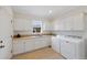 Bright laundry room with white cabinets, countertop, sink, washer, and dryer, illuminated by a window at 8155 W Tennessee Dr, Lakewood, CO 80226