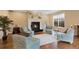 Cozy living room featuring a fireplace, hardwood floors, and bright windows at 8155 W Tennessee Dr, Lakewood, CO 80226