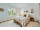 Bright bedroom with a large window, shutter blinds, and neutral decor and patterned comforter at 13990 E Chenango Dr, Aurora, CO 80015