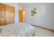 Cozy bedroom features a double bed with patterned bedding, closet, and artistic wall decor at 13990 E Chenango Dr, Aurora, CO 80015