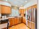 Well-lit kitchen featuring stainless steel appliances, wood cabinets, and granite countertops at 13990 E Chenango Dr, Aurora, CO 80015