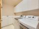 Well-lit laundry room features newer appliances and ample storage and counter space at 13990 E Chenango Dr, Aurora, CO 80015