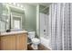 Well-lit bathroom with a shower and tub combo, vanity with storage, and white porcelain toilet at 3940 Malaya St, Denver, CO 80249