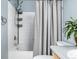 Bright bathroom featuring a neutral colored shower curtain, white tiled tub, and silver shower fixture at 3940 Malaya St, Denver, CO 80249