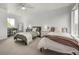 Large bedroom with two twin beds, light colored walls, neutral carpet, and large window at 3940 Malaya St, Denver, CO 80249
