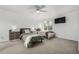 Spacious bedroom with two twin beds, neutral carpet, ceiling fan, and bright natural light at 3940 Malaya St, Denver, CO 80249