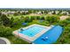 Aerial view of a community pool with lap lanes, vibrant blue umbrellas, and a recreational area at 3940 Malaya St, Denver, CO 80249