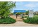 Fenced dog park entrance with shade structure, play equipment, and visible park regulations signage at 3940 Malaya St, Denver, CO 80249