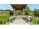Beautiful gazebo with stairs, green railings, painted pillars, and surrounding landscaping, steps from a pond at 3940 Malaya St, Denver, CO 80249