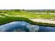Picturesque view of a golf course with a tranquil pond, vibrant greenery, and sand traps at 3940 Malaya St, Denver, CO 80249