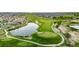 Scenic aerial view of the golf course featuring lush green fairways, a serene pond, and nearby homes at 3940 Malaya St, Denver, CO 80249