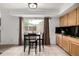 Eat-in kitchen area with views of the backyard, a table, wooden cabinets and dark countertops at 3940 Malaya St, Denver, CO 80249