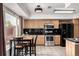 Bright eat-in kitchen with stainless steel appliances and a breakfast table beneath tray ceiling lighting at 3940 Malaya St, Denver, CO 80249