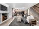 Comfortable living room showcases a fireplace, stairs, and seamless flow into the kitchen and dining area at 3940 Malaya St, Denver, CO 80249