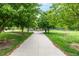 Scenic park pathway lined with mature trees, benches, and manicured landscaping for a tranquil experience at 3940 Malaya St, Denver, CO 80249