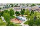 Playground with colorful play structures, swings, benches and a nearby school building at 3940 Malaya St, Denver, CO 80249