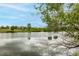 A serene pond view shows calm water and mature trees offering a peaceful backdrop for community enjoyment at 3940 Malaya St, Denver, CO 80249