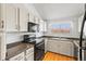 A functional kitchen featuring white cabinets, black appliances, a stainless steel sink, and a window that brings in natural light at 3576 S Depew St # 302, Lakewood, CO 80235