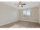 Bright bedroom with floral wallpaper accent wall, ceiling fan, and cozy carpet at 11912 Madison Pl, Thornton, CO 80223