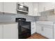 Bright eat-in kitchen features white cabinets, granite countertops, and stainless steel appliances at 11912 Madison Pl, Thornton, CO 80223