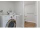Laundry room with modern washer and dryer, adjacent to bathroom at 11912 Madison Pl, Thornton, CO 80223