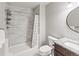 Bathroom features a shower with gray tiling, granite countertop and round mirror at 18672 E Chaffee Pl, Denver, CO 80249