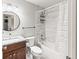 Bathroom features a shower with subway tiling, granite countertop, and a round mirror at 18672 E Chaffee Pl, Denver, CO 80249