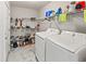 A bright laundry room featuring tile floors, shelving, and modern washer and dryer at 18672 E Chaffee Pl, Denver, CO 80249