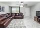 Comfortable living room features a large sectional sofa, ceiling fan, and bright window at 18672 E Chaffee Pl, Denver, CO 80249