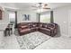 Spacious living room with comfortable leather sofa, modern ceiling fan, and bright windows at 18672 E Chaffee Pl, Denver, CO 80249