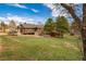 A beautiful shot of the rear of the home, enhanced by a spacious green yard and mature trees against a bright, clear sky at 459 Virginia Ave, Palmer Lake, CO 80133