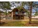 Exterior of a two-story home featuring decks, a fenced yard, and mature trees at 459 Virginia Ave, Palmer Lake, CO 80133