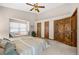 Well-lit bedroom with a comfortable window seat, ceiling fan, plush carpet, and natural wood doors at 459 Virginia Ave, Palmer Lake, CO 80133