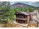 Stunning two-story home with a spacious balcony, nestled against a backdrop of lush greenery and mountainous scenery at 459 Virginia Ave, Palmer Lake, CO 80133