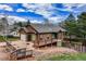 Charming raised two-story home with brown stucco siding, gray roof, and lovely landscaping at 459 Virginia Ave, Palmer Lake, CO 80133