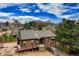 Charming home with a deck, surrounded by mature trees and lush greenery, seamlessly blending into the natural landscape at 459 Virginia Ave, Palmer Lake, CO 80133