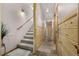 Hallway features carpeted stairs, natural wood paneling, tile floors, and updated lighting fixtures at 459 Virginia Ave, Palmer Lake, CO 80133