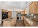 Bright kitchen features stainless steel appliances, natural wood cabinetry, granite countertops, kitchen island, and tile flooring at 459 Virginia Ave, Palmer Lake, CO 80133